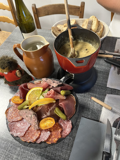 Fondue et plateau de charcuteries servis ensemble chez Fondue & Co