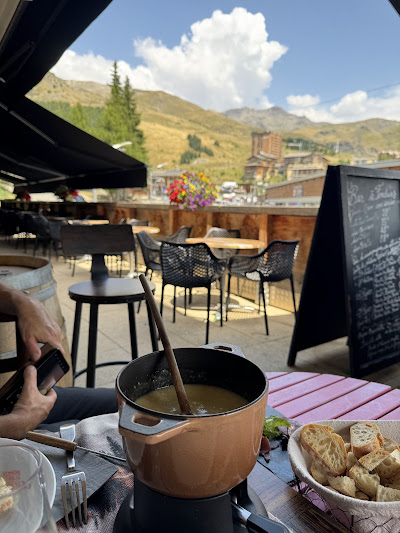 Terrasse de Fondue & Co avec fondue fumante et vue panoramique sur les sommets d'Orcières Merlette